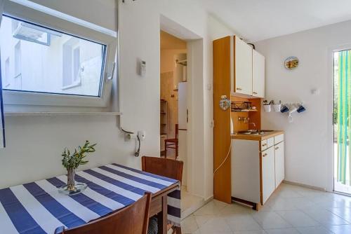 a kitchen and dining room with a table and a window at Ivka 2 in Mali Lošinj