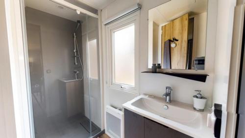 une salle de bain avec un lavabo, une douche et un miroir dans l'établissement Camping Officiel Siblu Les Viviers, à Lège-Cap-Ferret