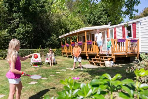 a young girl playing with a frisbee in a yard at Camping Officiel Siblu Domaine de Litteau in Litteau