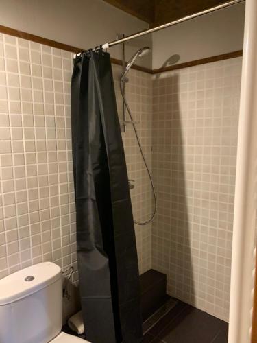 a bathroom with a shower with a black shower curtain at Casa en Estavar Residential con jardín y piscina in Estavar