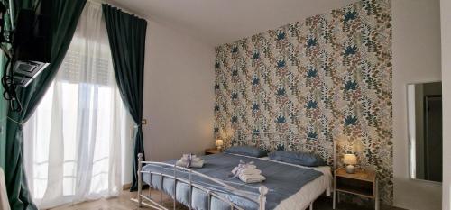 a bedroom with a bed with blue sheets and a wallpaper at PANORAMICO in Catania