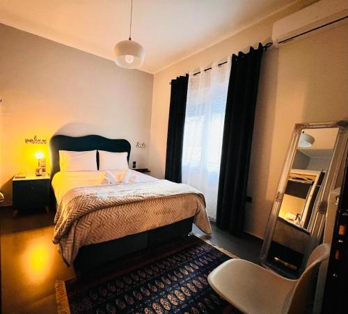 ein Schlafzimmer mit einem Bett, einem Spiegel und einem Stuhl in der Unterkunft Phoenix Garden Apartment I in Athen