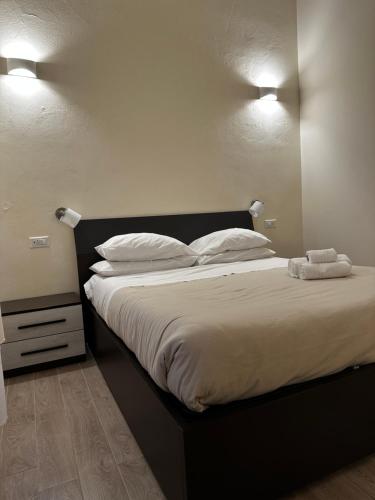 a bedroom with a large bed with white sheets and pillows at Domo Achenza in Terralba
