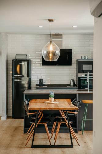 a kitchen with a wooden table and a refrigerator at tuGuest Carretera de la Sierra Apartment in Granada
