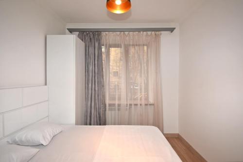 a bedroom with a white bed and a window at 19Tumanyan Excellent apartment in the centre of capital in Yerevan