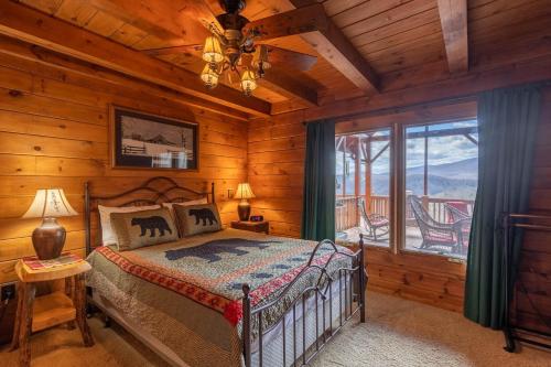 ein Schlafzimmer mit einem Bett und einem Fenster in einer Hütte in der Unterkunft Beary Relaxing Cabin in Banner Elk