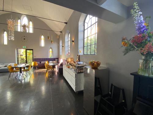 ein großes Wohnzimmer mit einem Tisch und Stühlen in der Unterkunft Valerius Boutique Hotel in Wormer