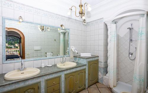 a bathroom with two sinks and a shower and a tub at Villa Palumbo in Positano