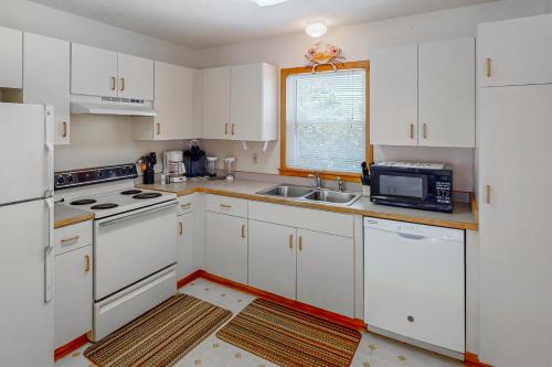 a kitchen with white cabinets and a sink and a microwave at Siren's Song #D7-HC in Avon