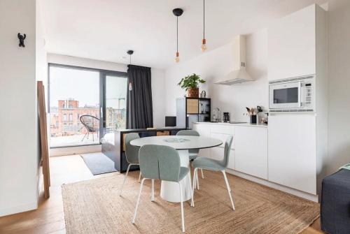 a kitchen and living room with a table and chairs at New apartment with big terrace and great views! in Leuven