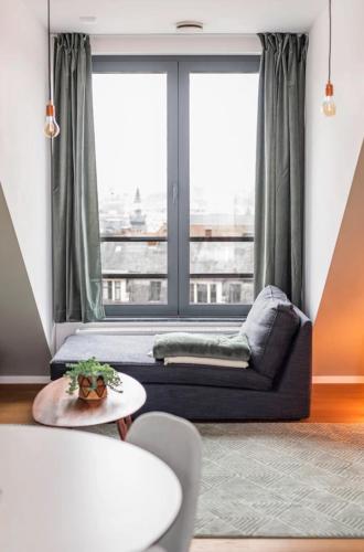 a living room with a couch and a large window at New apartment with big terrace and great views! in Leuven