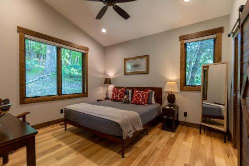 Un dormitorio con una cama y dos ventanas. en Apres Chalet at Eagles Nest, en Banner Elk