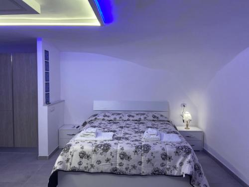 - une chambre blanche dotée d'un lit avec un couvre-lit floral dans l'établissement Scalinatella, à Naples