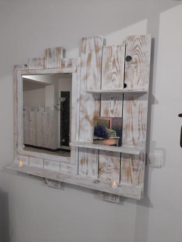 um espelho pendurado numa parede com prateleiras em Chez Sabine et Patrick em Narbona