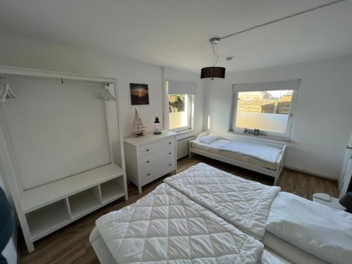 a bedroom with a bed and a dresser and two windows at Insel Koje 1 in Fehmarn