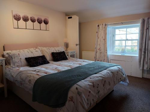 a bedroom with a bed and a window at The Coach House, Canonbie in Canonbie