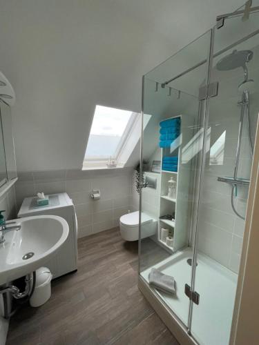 een badkamer met een glazen douche en een wastafel bij Ostsee Ferienwohnung Pelzerhaken in Neustadt in Holstein