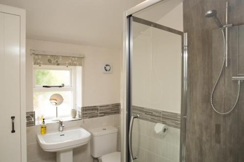 a bathroom with a toilet and a sink and a shower at Bramwood Cottages in Pickering