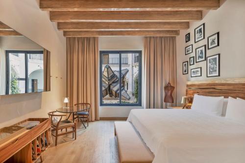 a bedroom with a large bed and a table and chairs at Live Aqua San Miguel de Allende in San Miguel de Allende