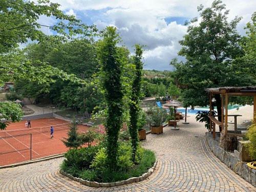 a park with a tree in the middle of a sidewalk at Yellow apartman in Vrnjačka Banja