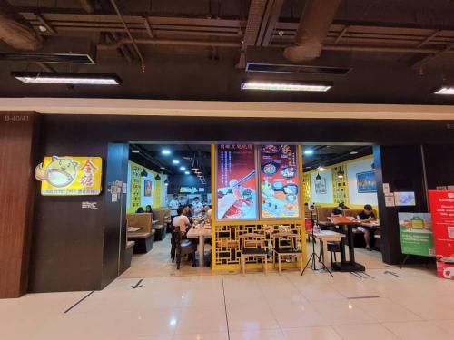 restauracja ze stołami i ludzie siedzący przy stołach w obiekcie BC The Loft 2A Imago Studio w mieście Kota Kinabalu