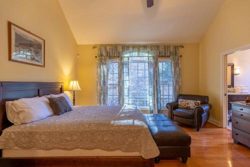 a bedroom with a bed and a chair and a window at Pisgah Retreat at Linville Falls in Linville Falls