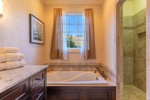 a bathroom with a tub and a shower and a window at Pisgah Retreat at Linville Falls in Linville Falls