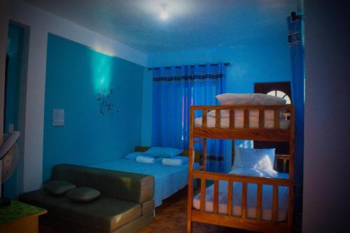 a blue room with a bunk bed and a couch at RnE Hometel Batanes in Ivana