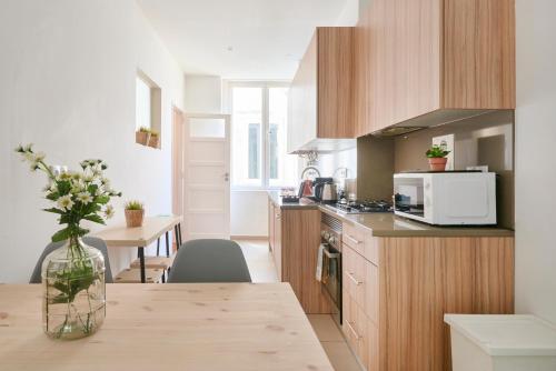 a kitchen with a table with a vase of flowers on it at Casa Portuguesa Chiado in Lisbon
