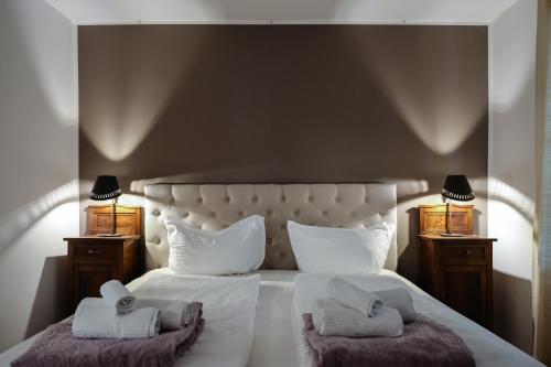 um quarto com uma grande cama branca com toalhas em Luxus-Idylle in the Downtown - Ulivo Suite em Bolzano