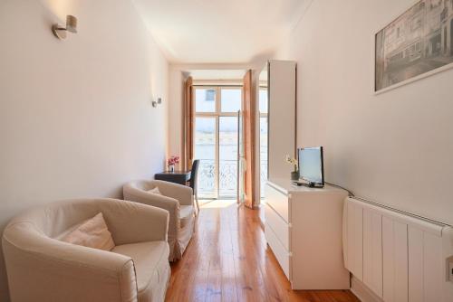a living room with two chairs and a television at Casa Portuguesa Chiado in Lisbon