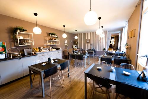 a restaurant with tables and chairs in a room at H&ocirc;tel Le Lion D'or in Bernay