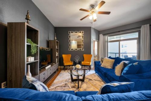 a living room with a blue couch and a tv at A Touch of Class in Houston