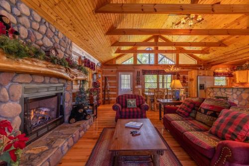 a living room with a stone fireplace in a log cabin at A Moon River View in Boone