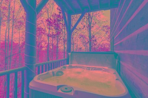 - une baignoire dans une chambre avec une forêt dans l'établissement A Moon River View, à Boone