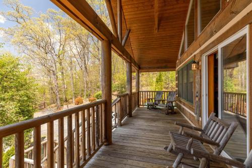 a porch of a cabin with two benches on it at A Moon River View in Boone