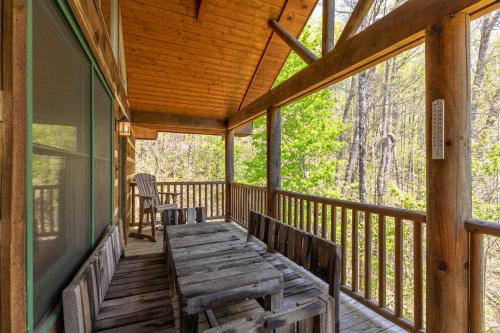 a porch with a wooden table and chairs on it at A Moon River View in Boone