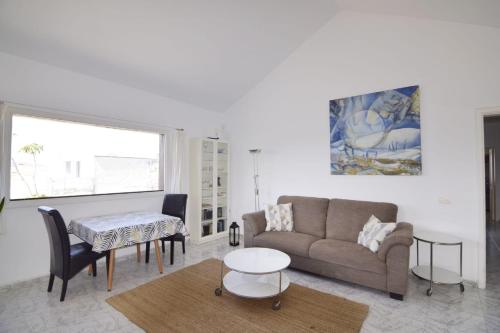 ein Wohnzimmer mit einem Sofa und einem Tisch in der Unterkunft Casa Famara in Teguise