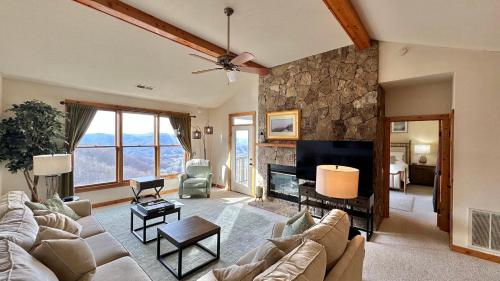 ein Wohnzimmer mit einem Sofa und einem Kamin in der Unterkunft Blue Ridge Mountain Air Retreat with epic mountain views! in Burnsville