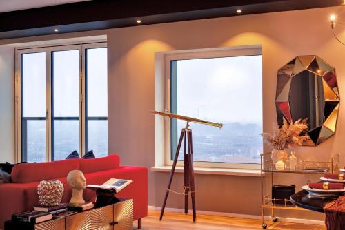 a living room with a red couch and large windows at Bohr Apartment Copenhagen in Copenhagen