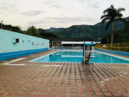 une piscine vide avec un palmier et des montagnes dans l'établissement Casa hotel hispania 2, à Hispania