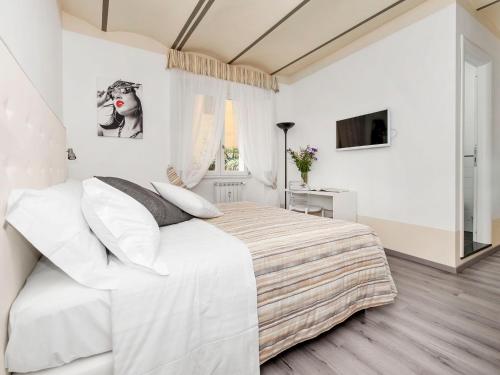 a white bedroom with a large bed and a window at White Rooms Colosseo in Rome