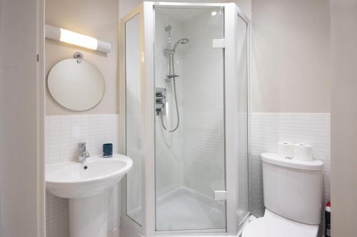 a white bathroom with a shower and a sink at Clearwater 31, The Lakehouse in Somerford Keynes