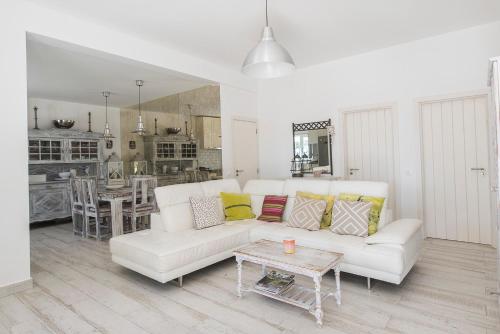 uma sala de estar com um sofá branco e uma mesa em The Beach House em Vila Nova de Cacela