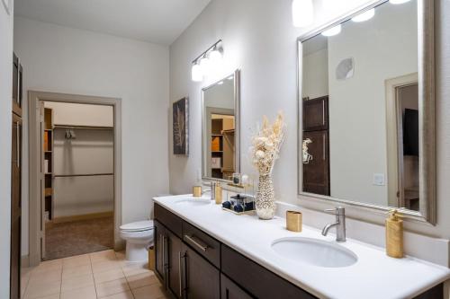 a bathroom with a sink and a toilet and a mirror at A Touch of Class in Houston