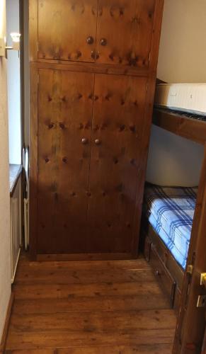 a bedroom with a bunk bed and a wooden cabinet at SAM sulle piste in La Thuile