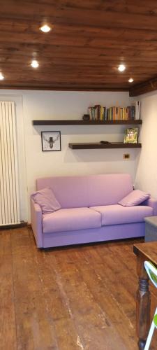 um sofá roxo sentado numa sala de estar em SAM sulle piste em La Thuile