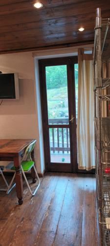 Pokój z drewnianym stołem i przesuwnymi szklanymi drzwiami w obiekcie SAM sulle piste w mieście La Thuile