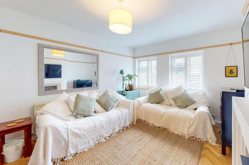 uma sala de estar com duas camas brancas e uma janela em Stunning 2 bed flat in Richmond em Kew