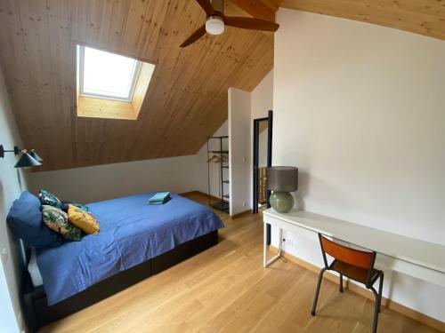 Schlafzimmer mit einem Bett, einem Schreibtisch und einem Fenster in der Unterkunft Le Pied du Loup - Maison de village clunisois au calme 6-7 personnes in Flagy